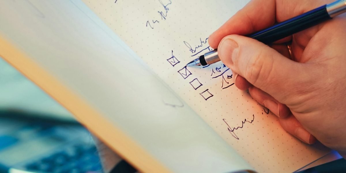 Person examining AI-generated content on a laptop and taking notes