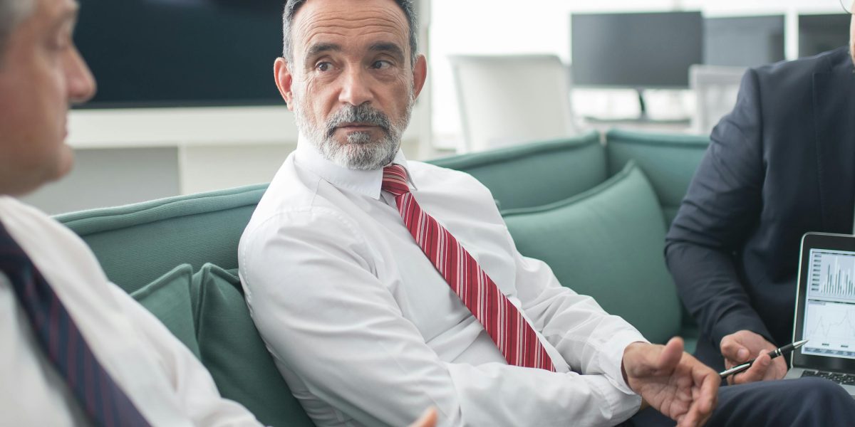 Business leaders engaged in a serious discussion, symbolizing the credibility risks and financial implications of AI hallucinations for organizations.