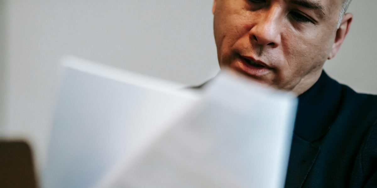 A person looks thoughtfully at a document, questioning the accuracy of information received.