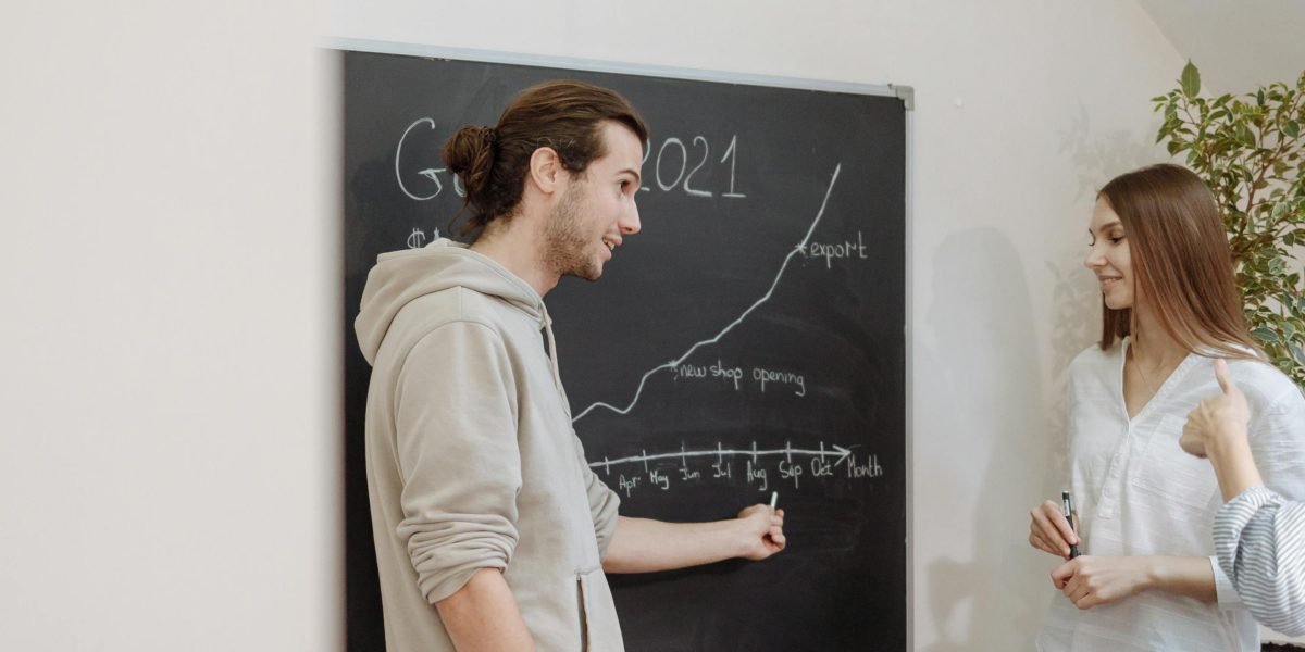 A team of professionals collaborating, discussing data trends and insights around a whiteboard.