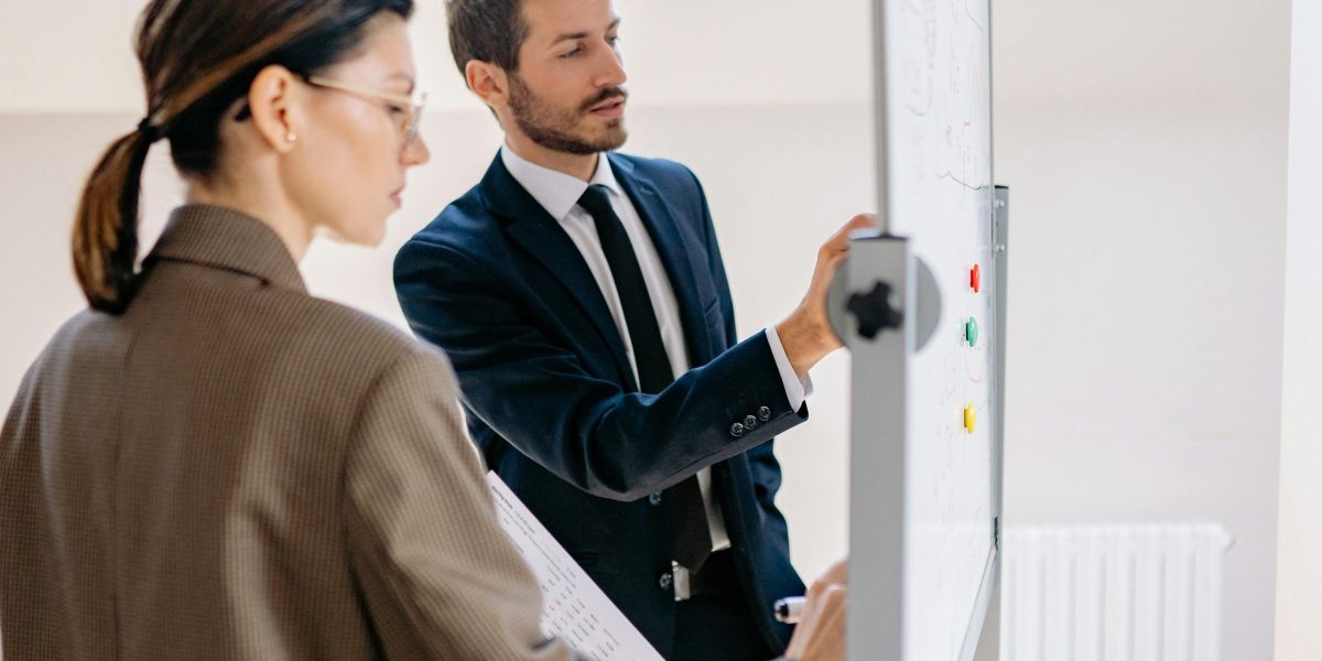 A team actively collaborating around a whiteboard, emphasizing the collective effort needed to implement AI content verification strategies.