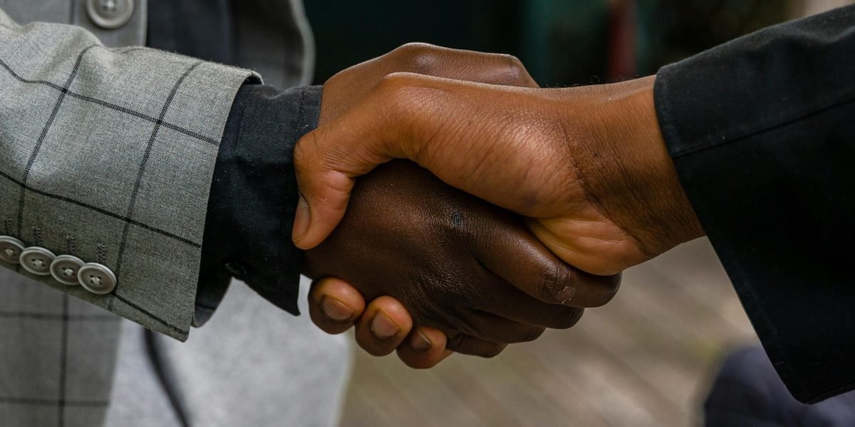 Two professionals shaking hands, symbolizing trust and reliability built through rigorous data analysis.