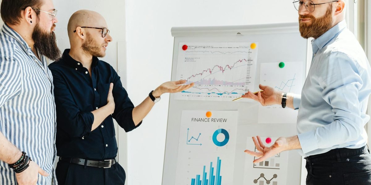 A group of colleagues actively discussing a project or workflow on a whiteboard, emphasizing integrated verification steps.