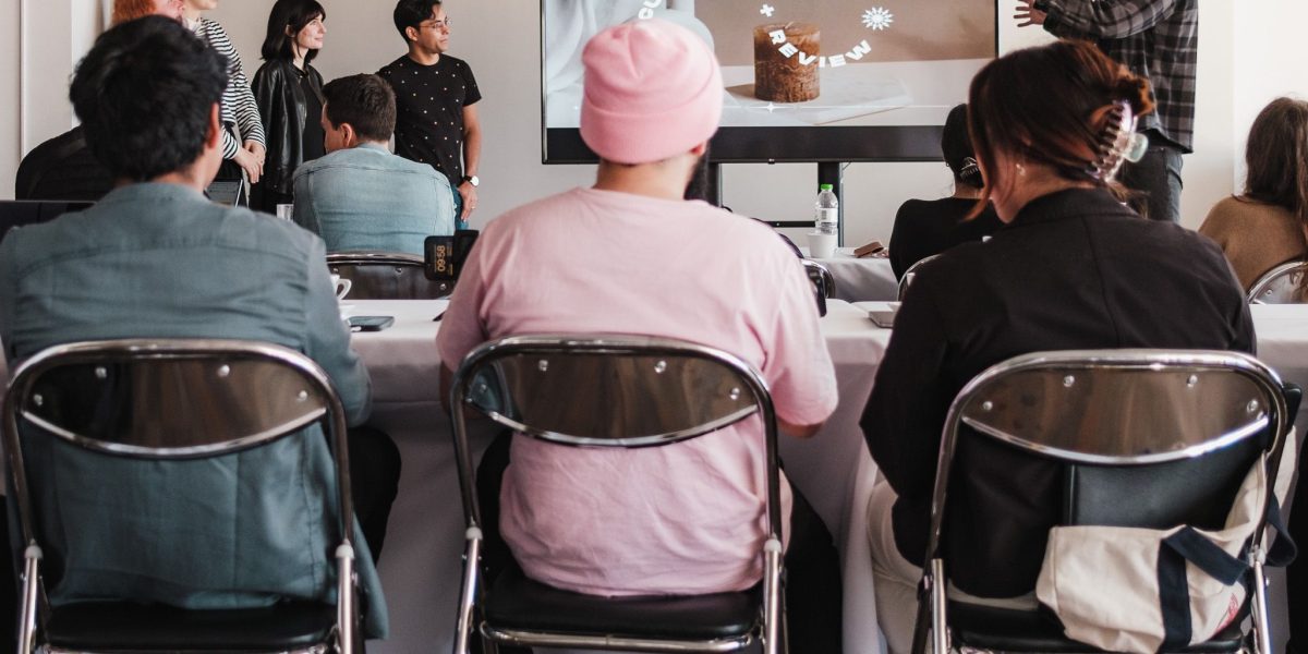 A group of business professionals engaged in a training or learning session, focused on continuous improvement.