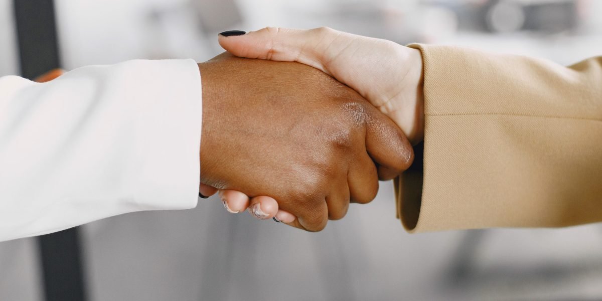 Two professionals shaking hands, signifying a successful meeting or new collaboration.