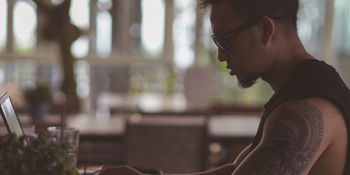 An individual working on their laptop at a coffee shop, illustrating the flexibility of remote work.