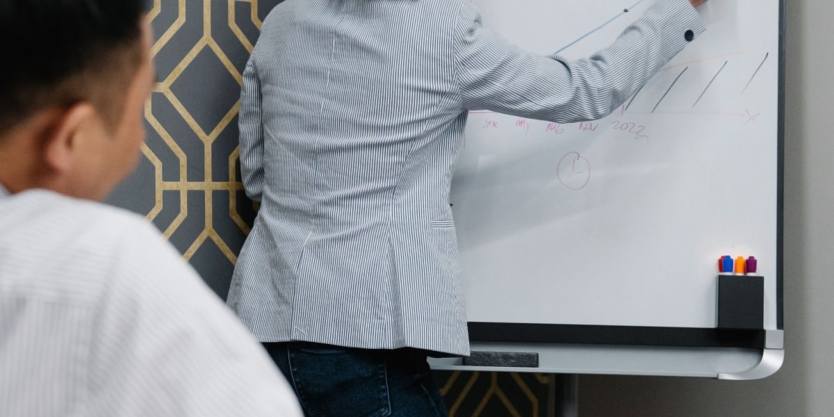 A team collaborates around a whiteboard, outlining a new workflow or problem-solving strategy.