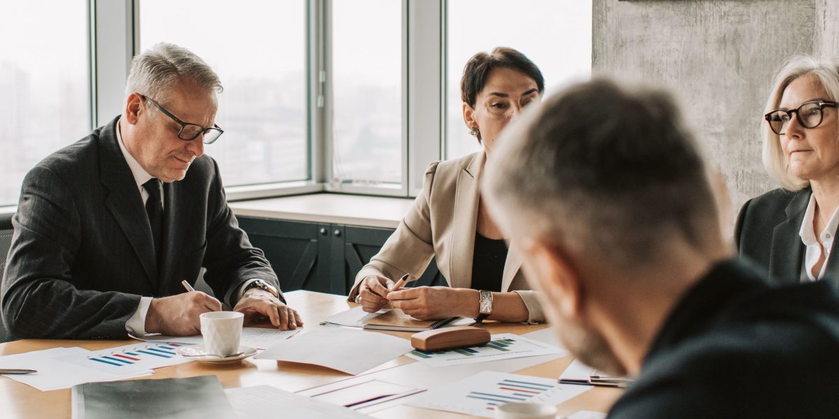 A team in a business meeting discusses serious consequences, highlighting the impact of AI errors on real-world operations.