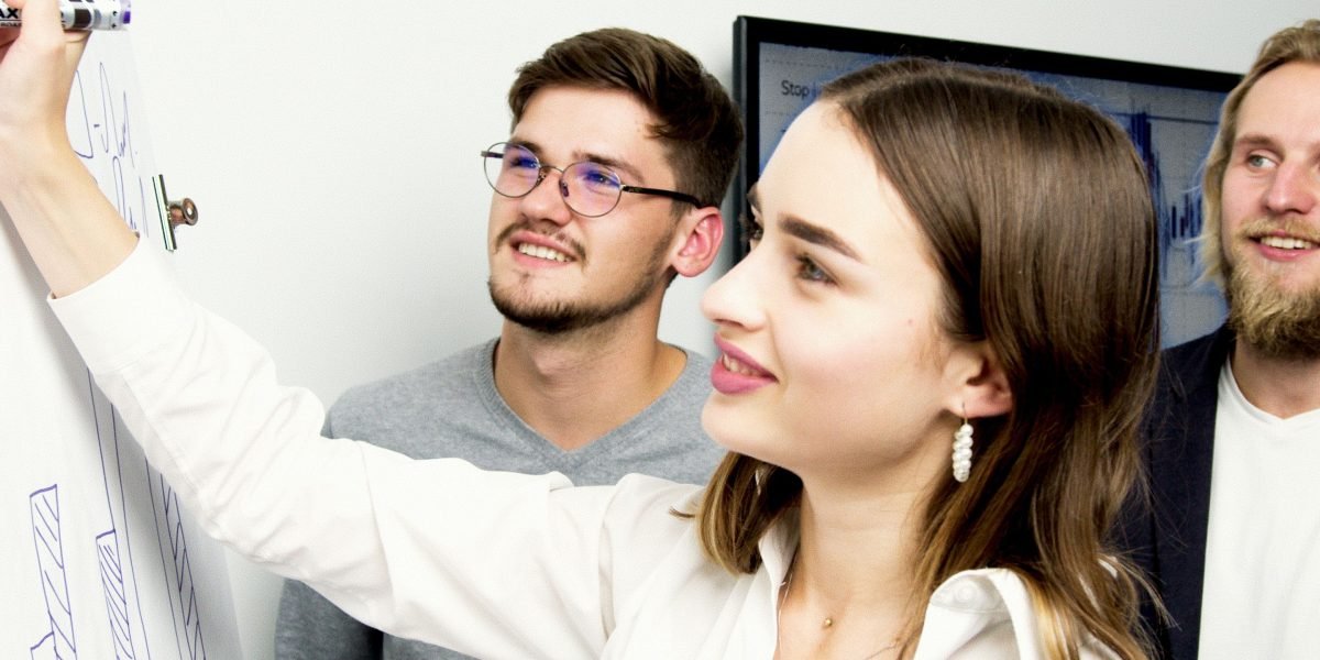 A team collaborates around a whiteboard, strategizing against potential cybersecurity threats posed by AI hallucinations.