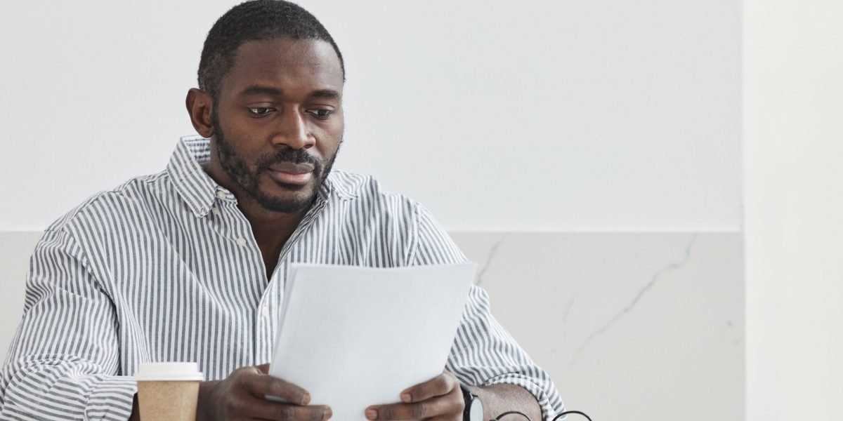 A person looks thoughtfully at a research paper, reflecting on the importance of accuracy and integrity in academic work.